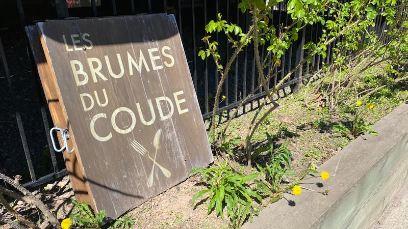 A brown wooden sign reads: "Les Brumes Du Coude."