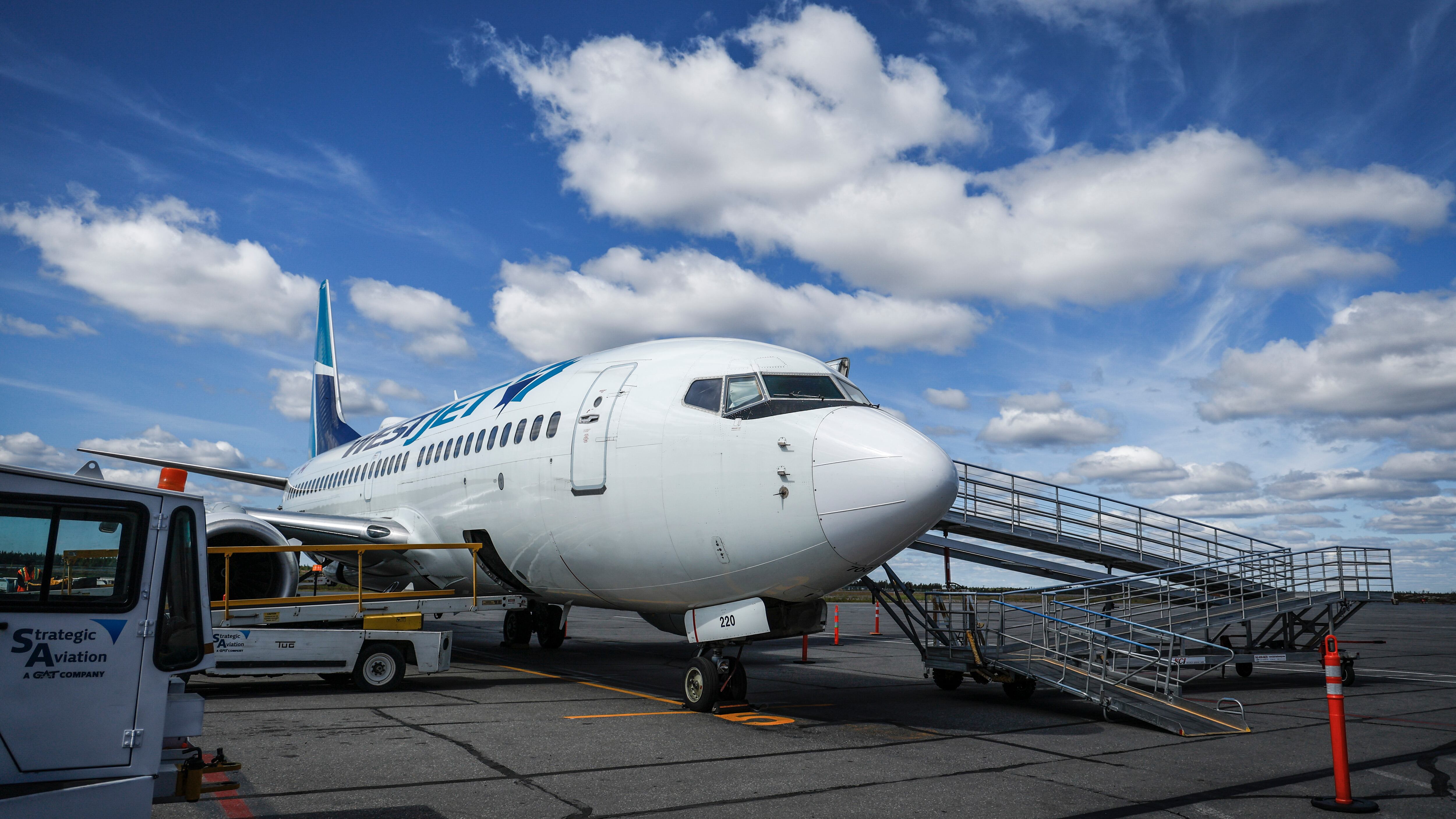 A WestJet plane on the tarmac at Yellowknife Airport on Tuesday, July 22, 2025. (THE CANADIAN PRESS/Jeff McIntosh)