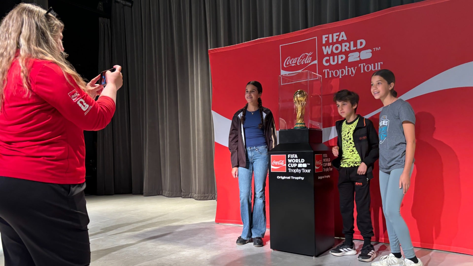 Fans pose with the FIFA World Cup Trophy.