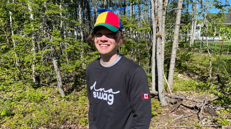 A young man is pictured wearing a colourful hat.