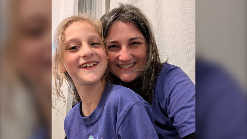 A young girl is pictured with her mom.
