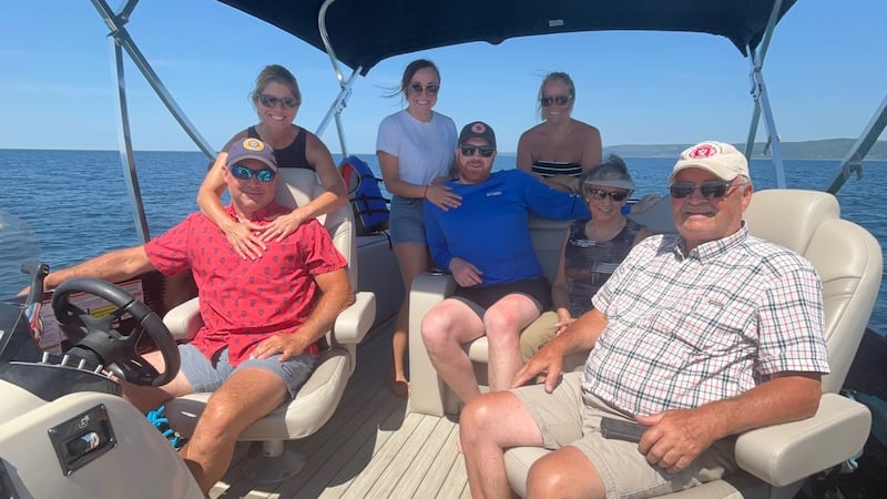 A group of people pose together on a boat.