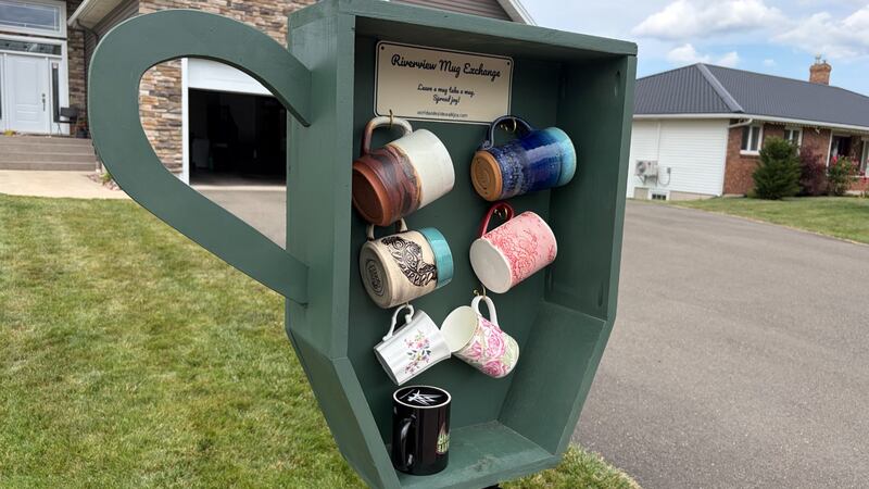 Coffee mugs are pictured in an outdoor holder.