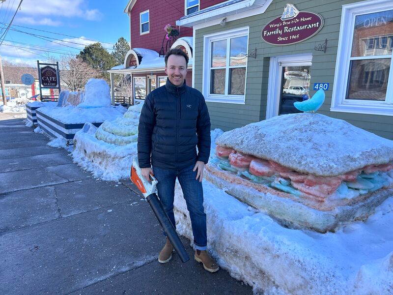Americo Pino, owner of the High Wheeler Cafe, stands in front of his business, and its snow sculptures, along Chebucto Street in Baddeck, N.S. (Ryan MacDonald/CTV)