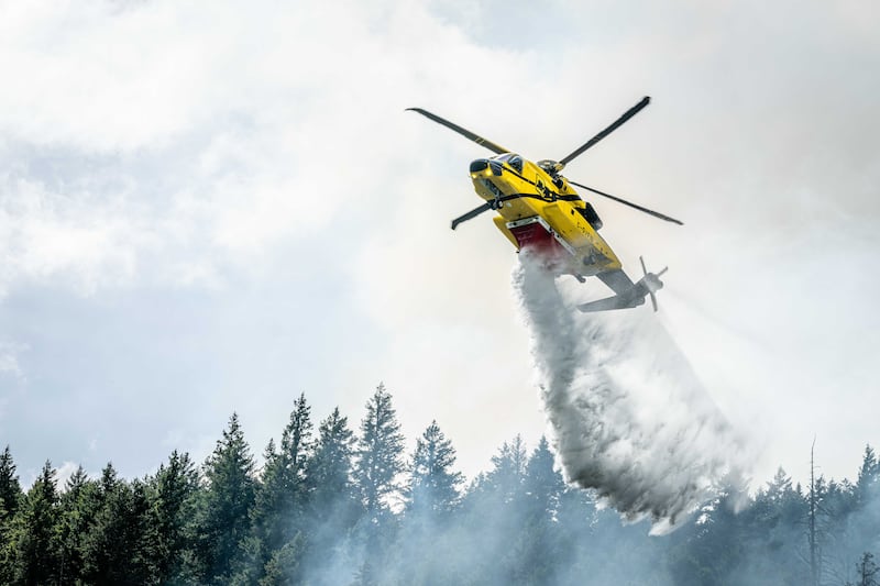 A helicopter drops water on a wildfire burning near Boston Bar, B.C. (BCWS)