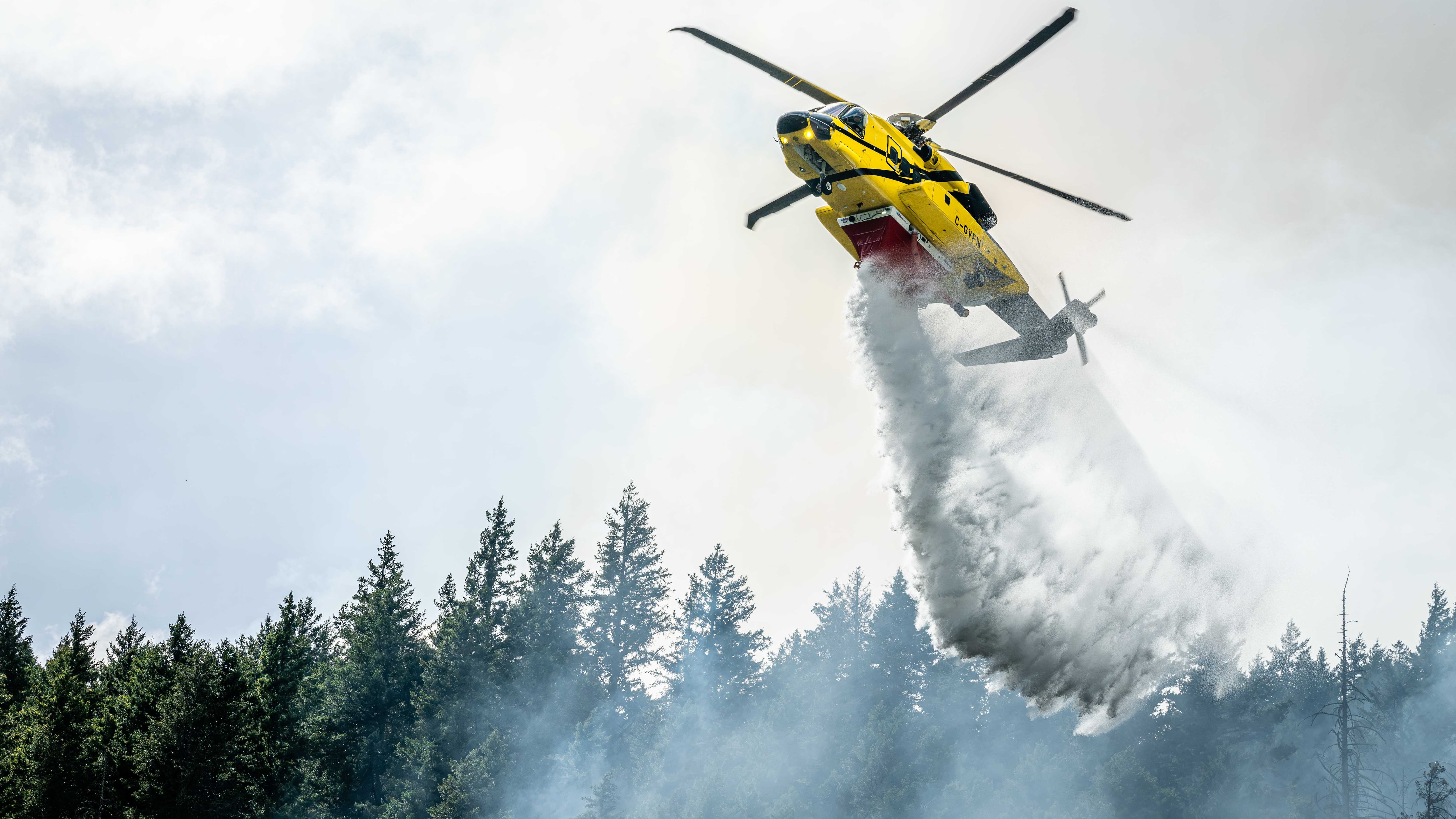A helicopter drops water on a wildfire burning near Boston Bar, B.C. (BCWS)