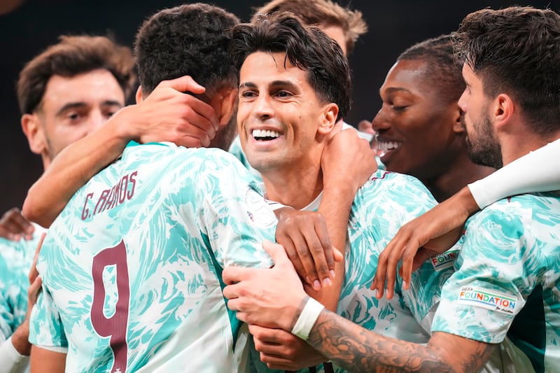 Portugal's Joao Cancelo, centre, celebrates scoring with teammates during the Nations League soccer match between Denmark and Portugal, in Copenhagen on Oct. 1, 2026. (Liselotte Sabroe / Ritzau Scanpix via AP)